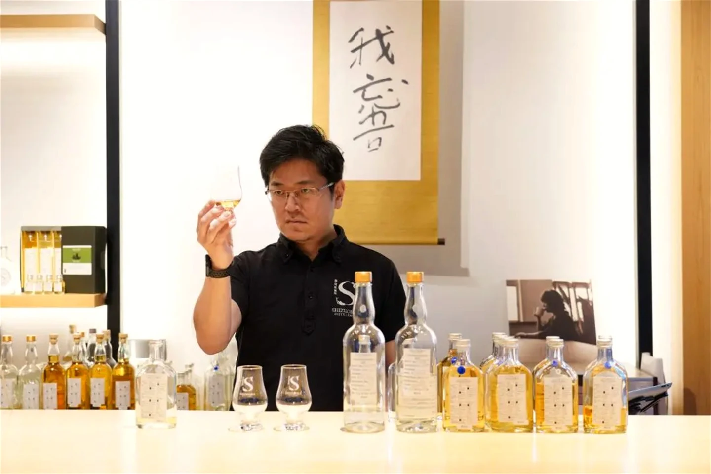 靜岡蒸溜所人員於品飲室觀察威士忌酒色,桌面陳列多款原酒樣本